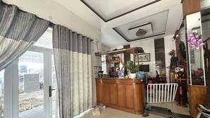 A room with a large sliding glass door, a wooden bar area with various items, and a white railing near the door. - SPOT ON 1188 Motel Hoa Cam (Da Nang)