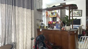 A room with a motorcycle, a wooden counter, and a window with curtains. - SPOT ON 1188 Motel Hoa Cam (Da Nang)