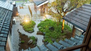 A rooftop garden with a wooden fence, gravel paths, and potted plants. - NIPPONIA Chichibu Monzenmachi (Chichibu)