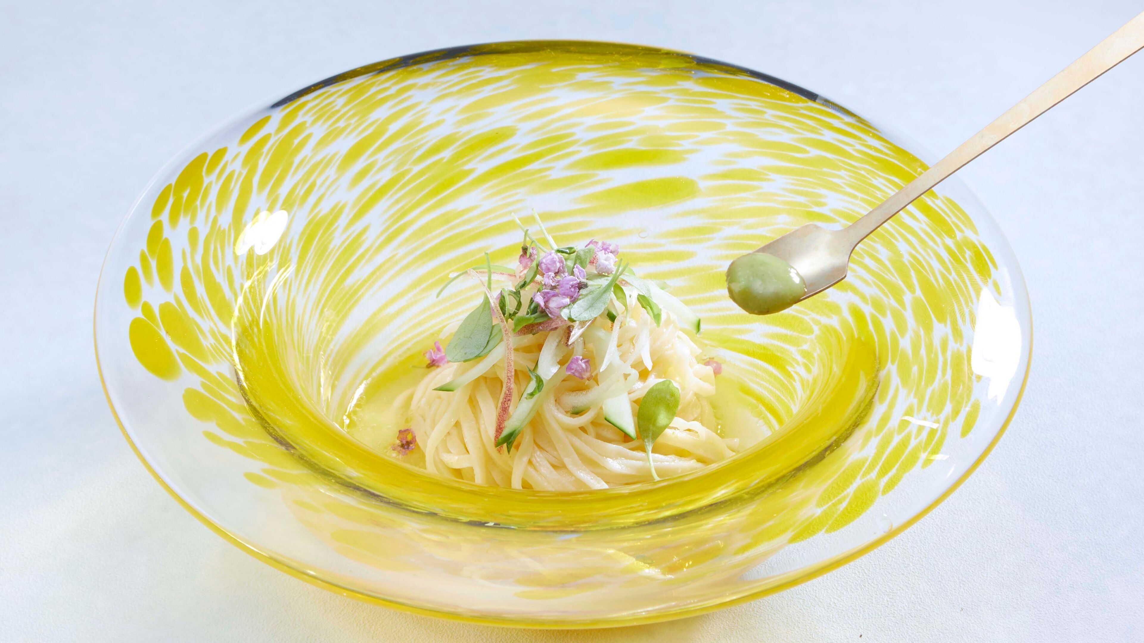 A bowl of pasta with a spoon.