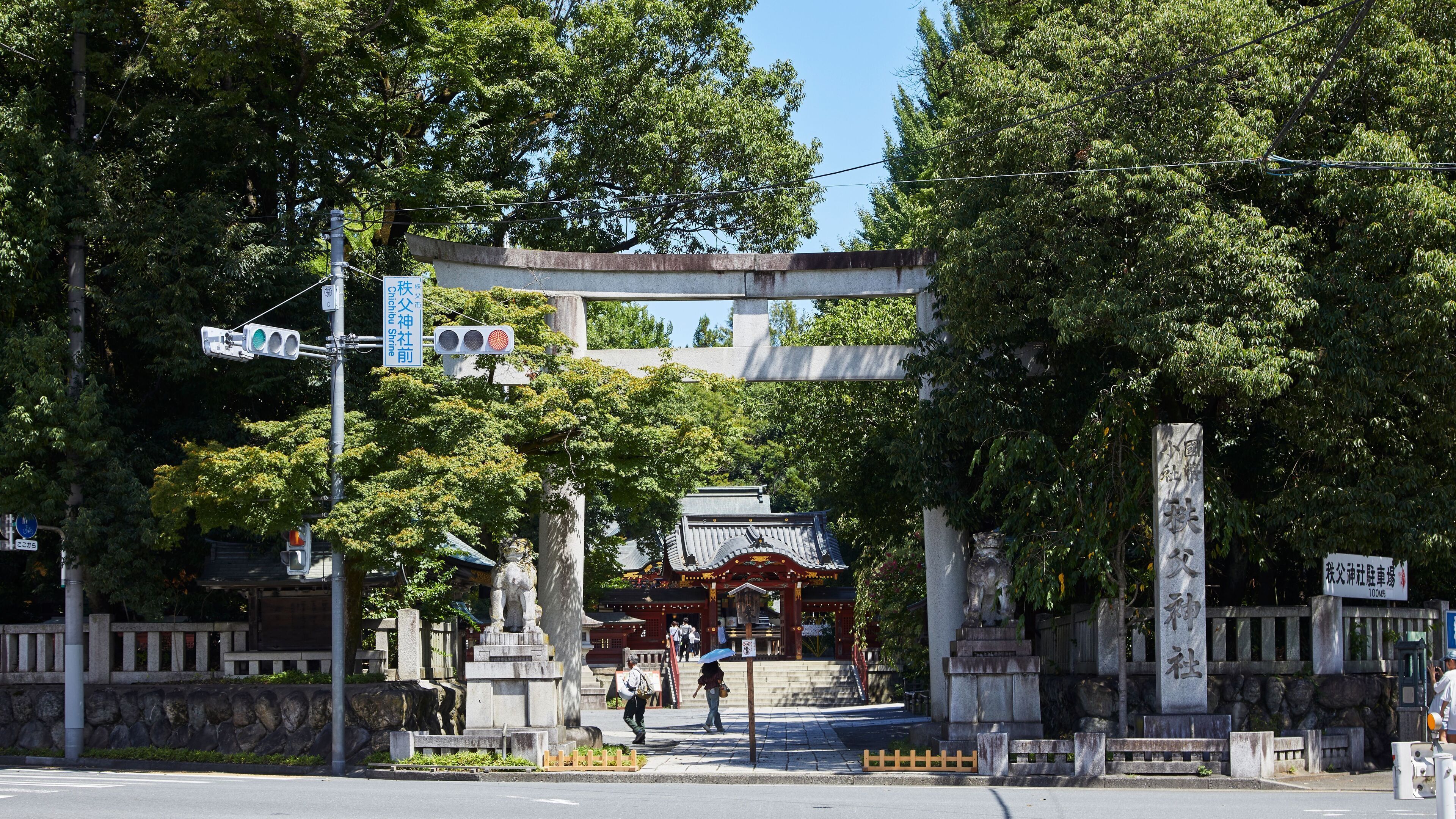 Un torii tradicional japonés con pilares de piedra y una estructura de madera al fondo.