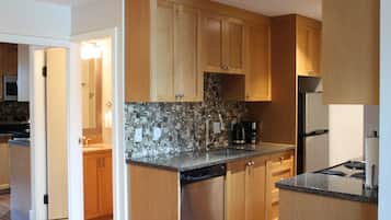 A modern kitchen with wooden cabinets, a tiled backsplash, and a dishwasher.