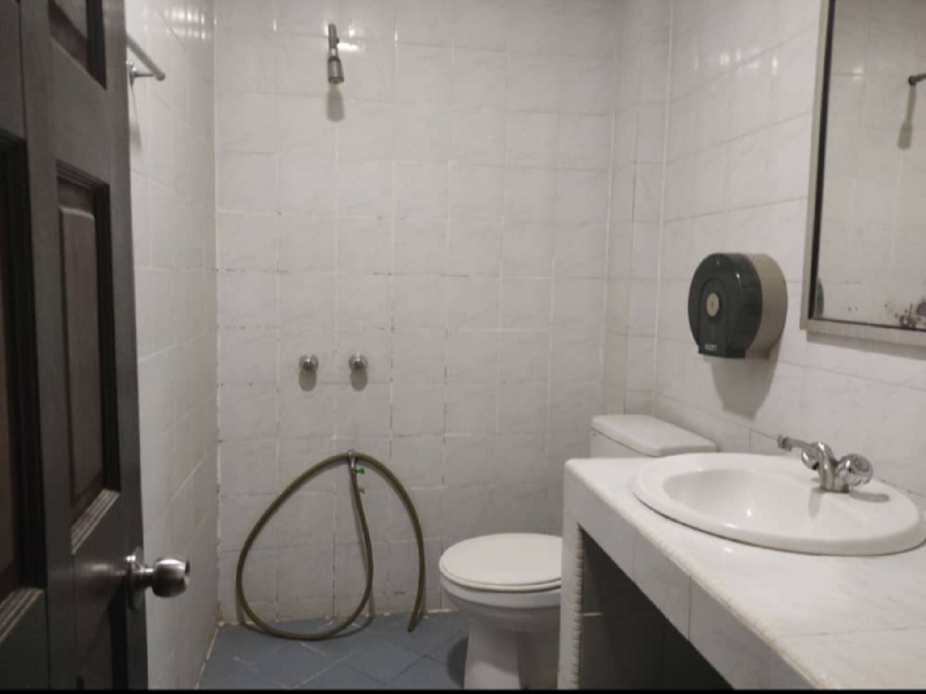A small bathroom with a toilet, sink, and a hand dryer.