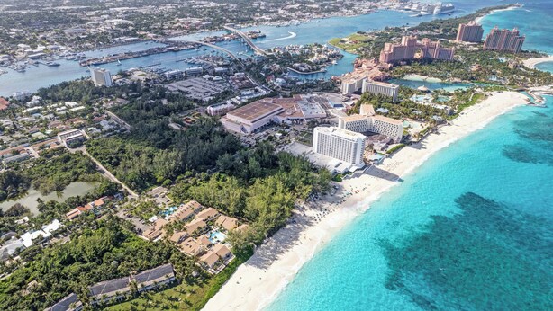 Ein Luftbild eines Küstenresorts mit Strandhäusern, einer Marina und mehreren Hochhäusern.
