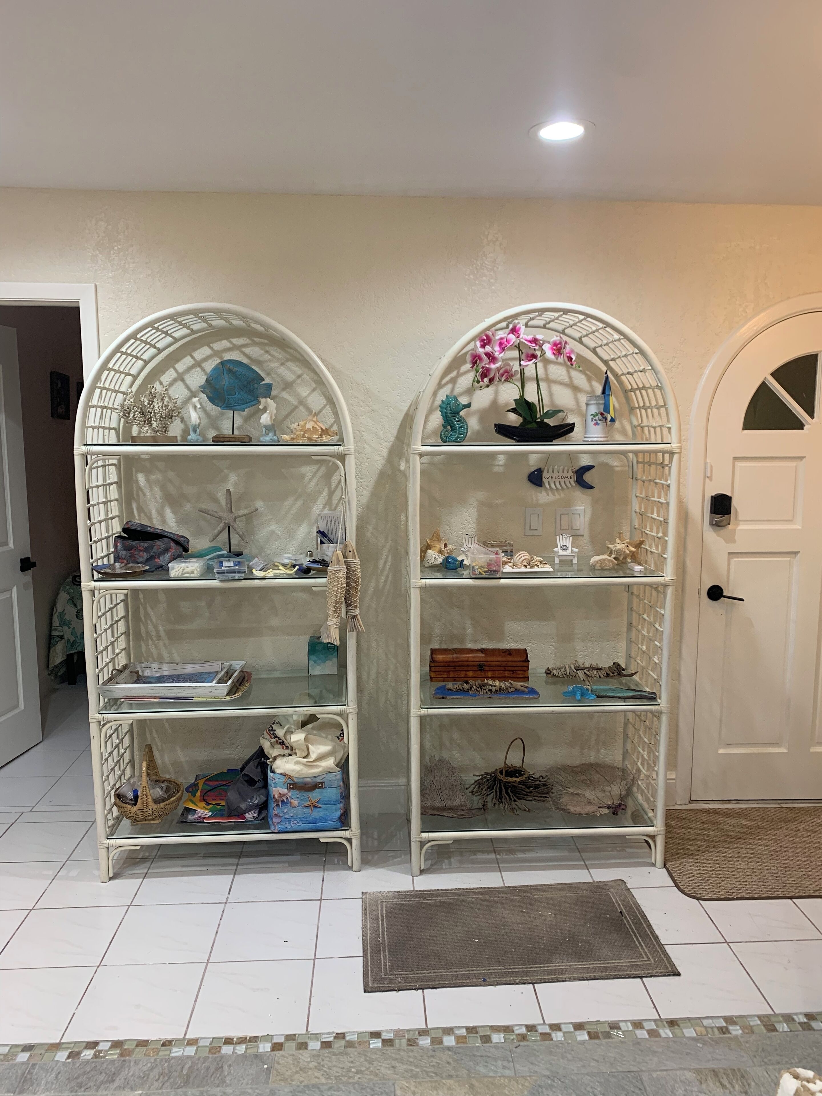 A room with two white arched shelving units filled with various decorative items.