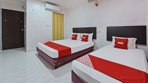 Une chambre d’hôtel avec deux lits, une armoire, un appareil de climatisation et une porte.