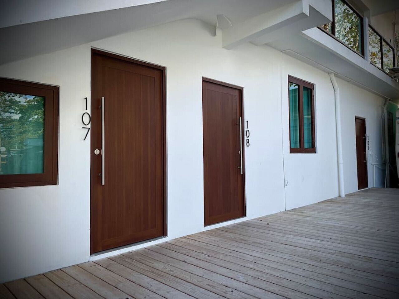 A modern building with three wooden doors, each marked with a number.