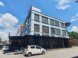 Um edifício de dois andares com teto plano e várias janelas.