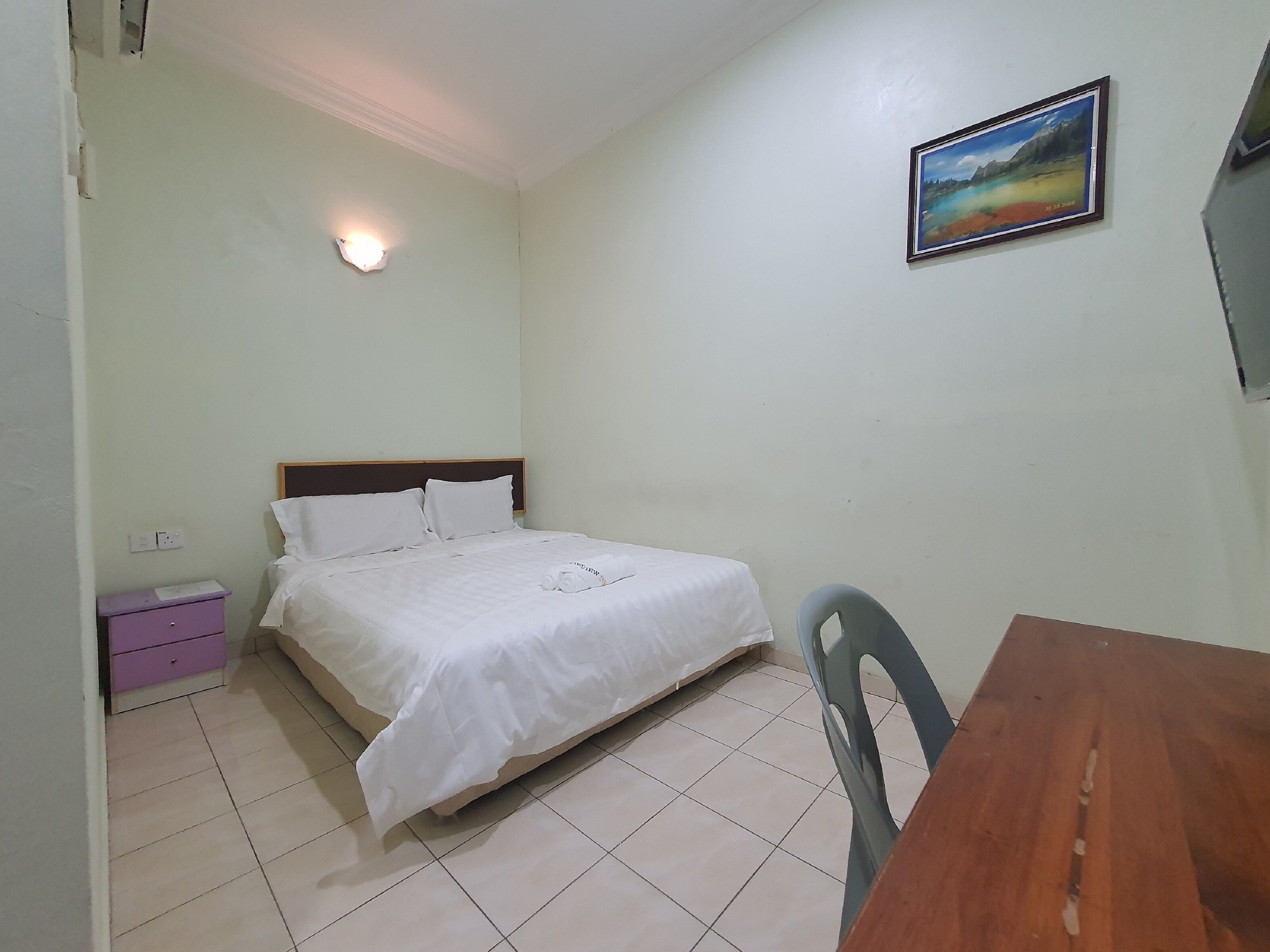 Une chambre à coucher avec un lit, une table de chevet, une table et une chaise.