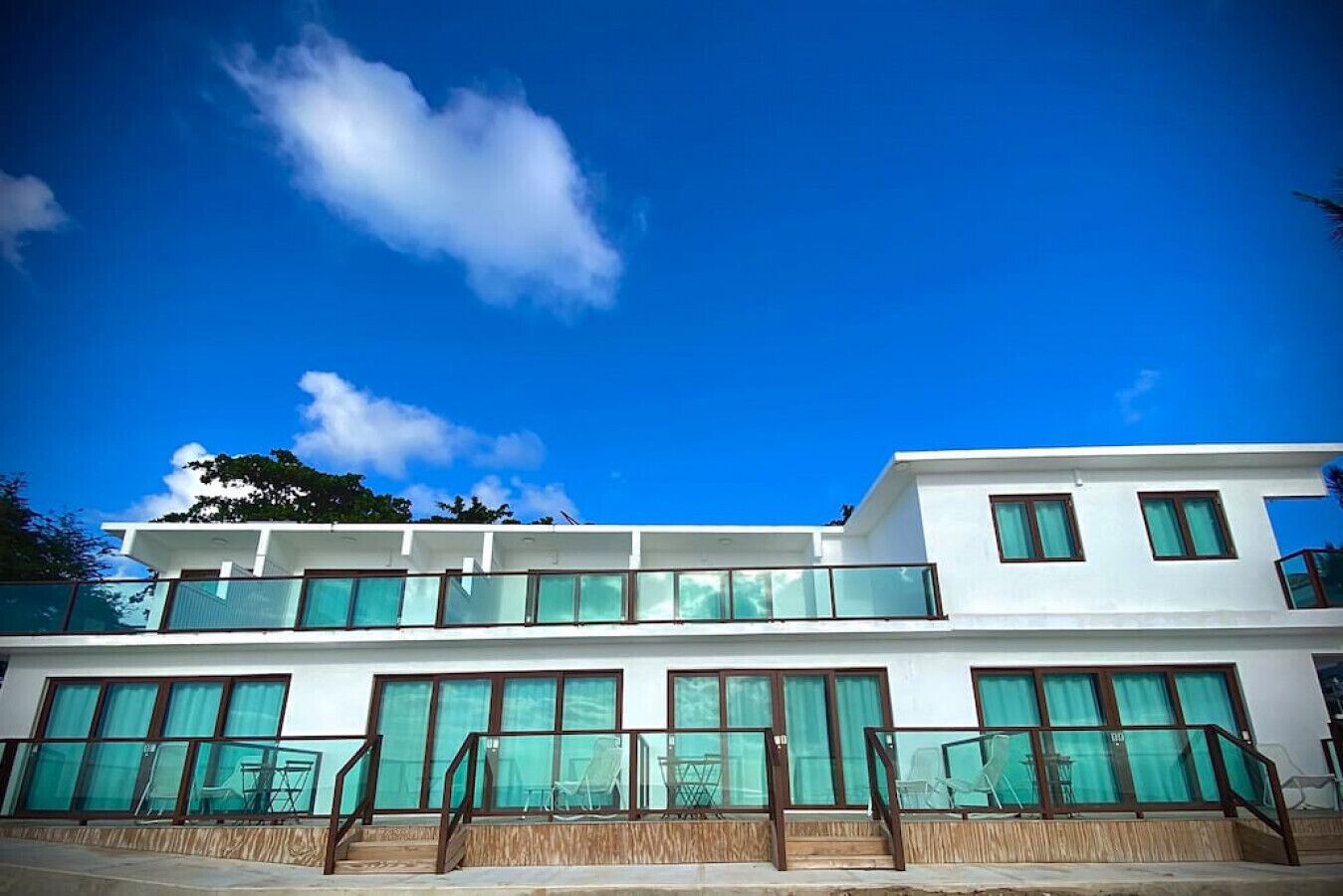 A modern two-story building with large windows and a balcony.