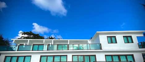 A modern two-story building with large windows and a balcony.
