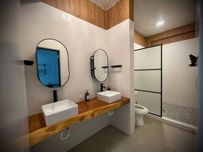 Une salle de bain moderne avec deux lavabos, une douche et des toilettes.