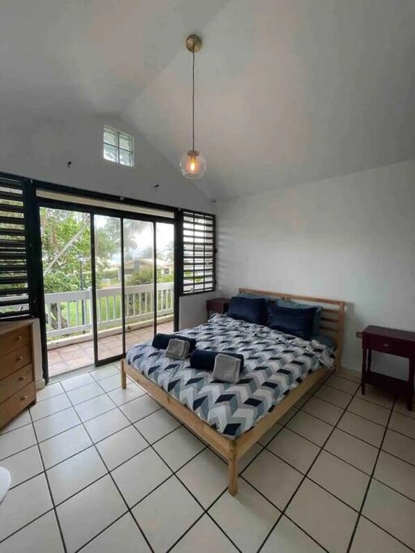 A bedroom with a bed, a dresser, and a nightstand.