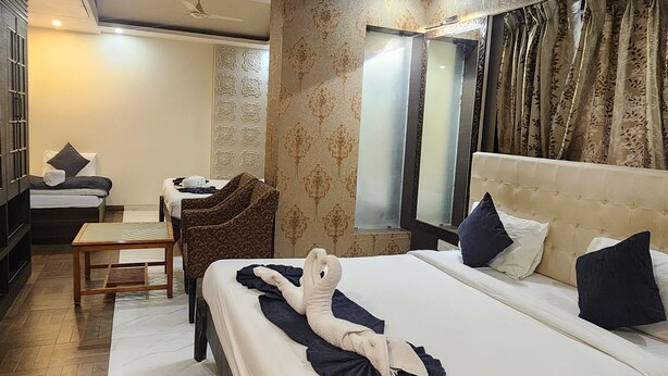 Quarto de hotel com cama grande, escrivaninha, cadeira e ventoinha no teto.