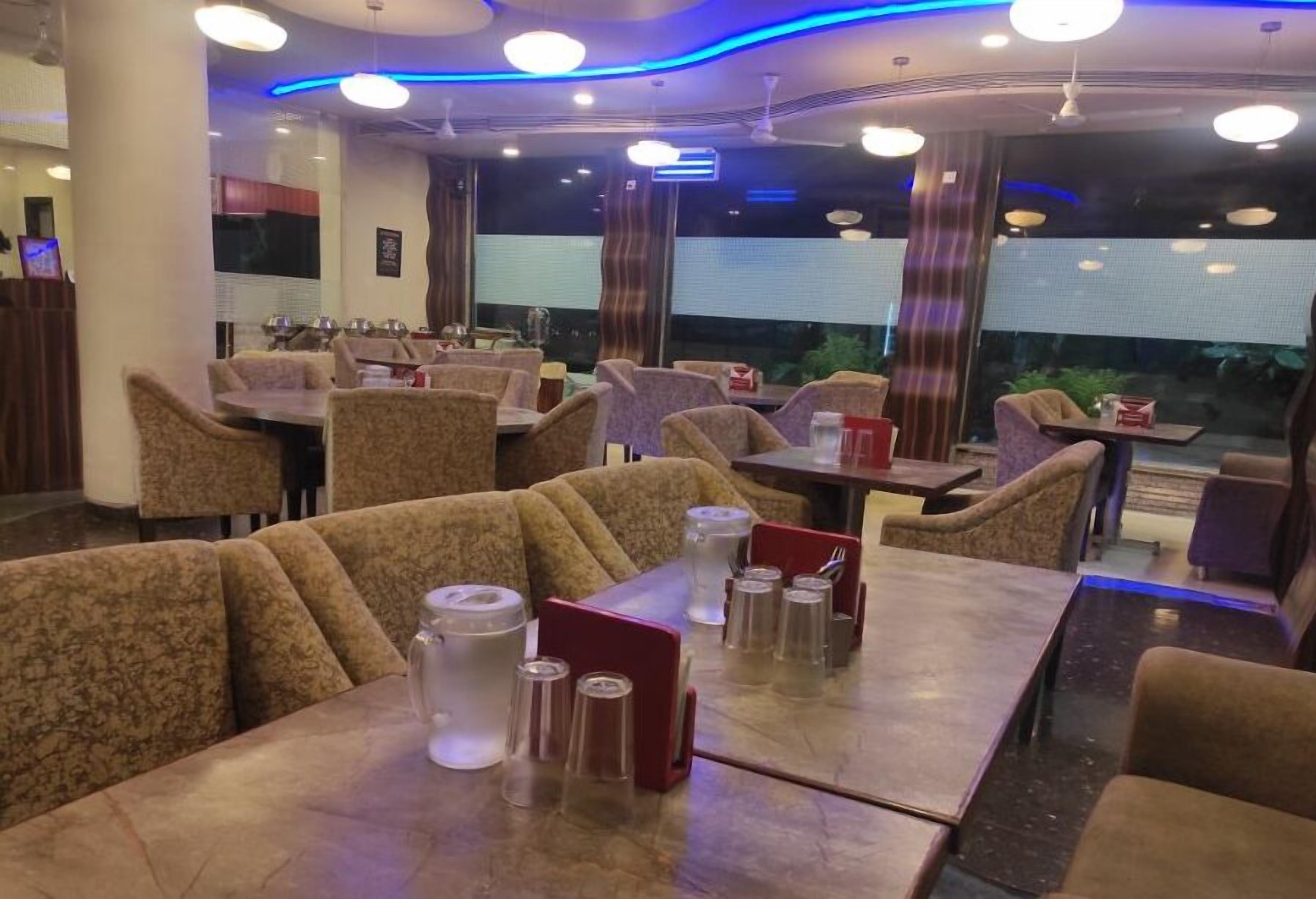 Interior de restaurant amb seients a cabines i taules, algunes amb cartes i plats.