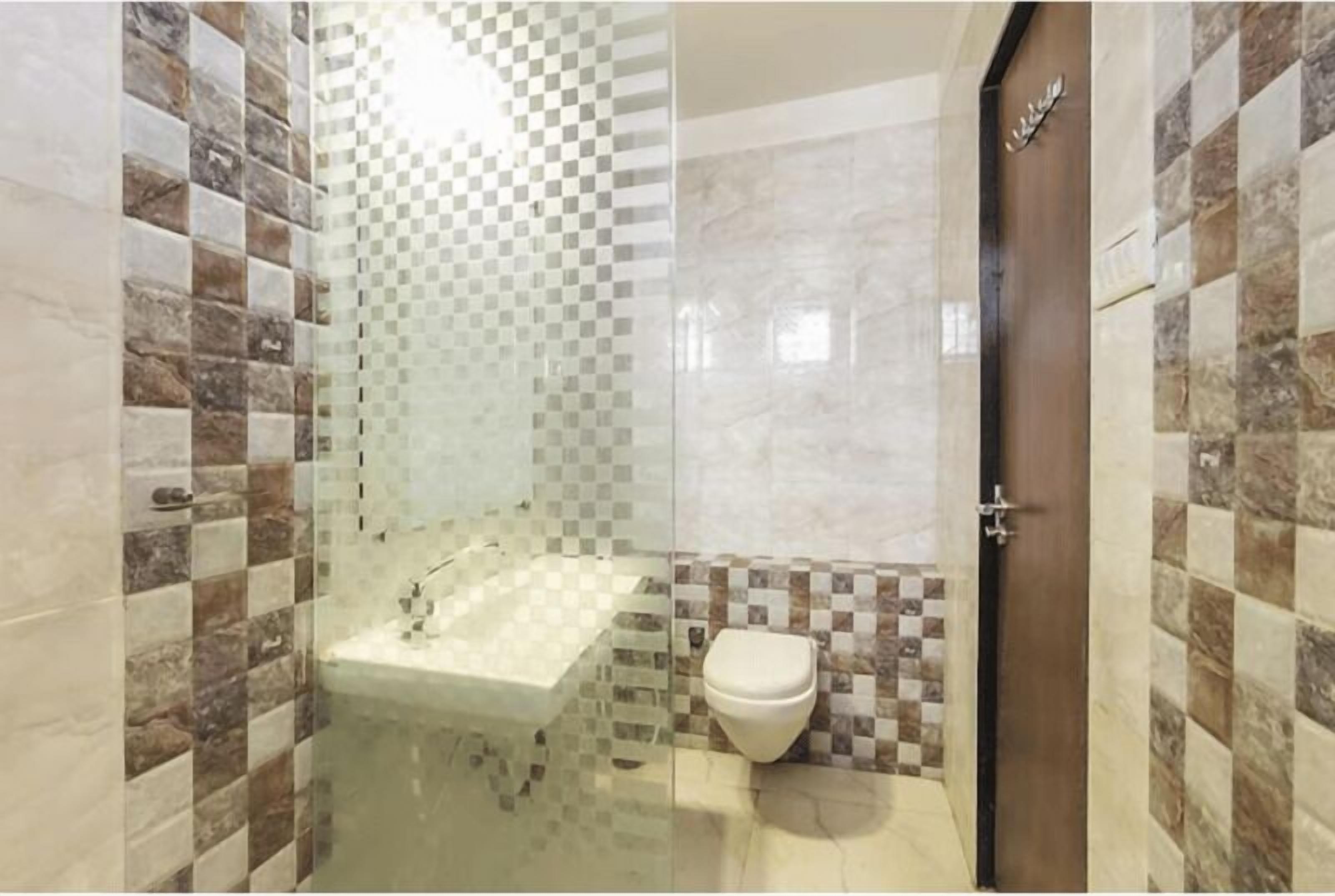 A bathroom with a glass-enclosed shower, a sink, and a toilet.