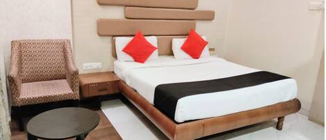 Una habitación de hotel con una cama, una silla, una mesita y una pared con un diseño geométrico.