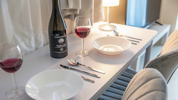 A dining table with a bottle of wine, glasses, and cutlery. - Esterrace Osaka West (Osaka)