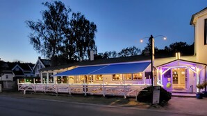 A cozy, well-lit building with a blue awning and a porch area, likely a restaurant or cafe. - Hotel und Restaurant Windland (Breege)