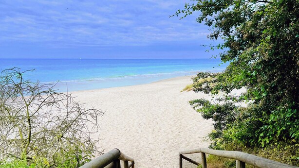 A sandy beach path leading to the ocean with a clear sky. - Hotel und Restaurant Windland (Breege)