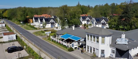 A hotel with a prominent blue roof, a sign reading "Windland Hotel & Restaurant," and a view of the surrounding residential area.
