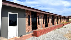 A row of single-story buildings with brick facades and large windows, likely part of a motel or hotel. - OYO 90818 Cemara Puri Resort & Spa  (Kuantan)