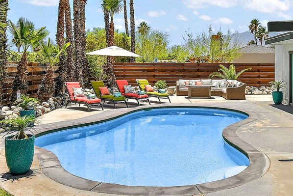 A swimming pool with lounge chairs and a wooden deck. - Perfect Pool Safari - Palm Springs (Palm Springs)