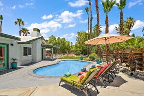 A backyard with a swimming pool, lounge chairs, and palm trees. - Perfect Pool Safari | Private Palm Springs Escape (Palm Springs)
