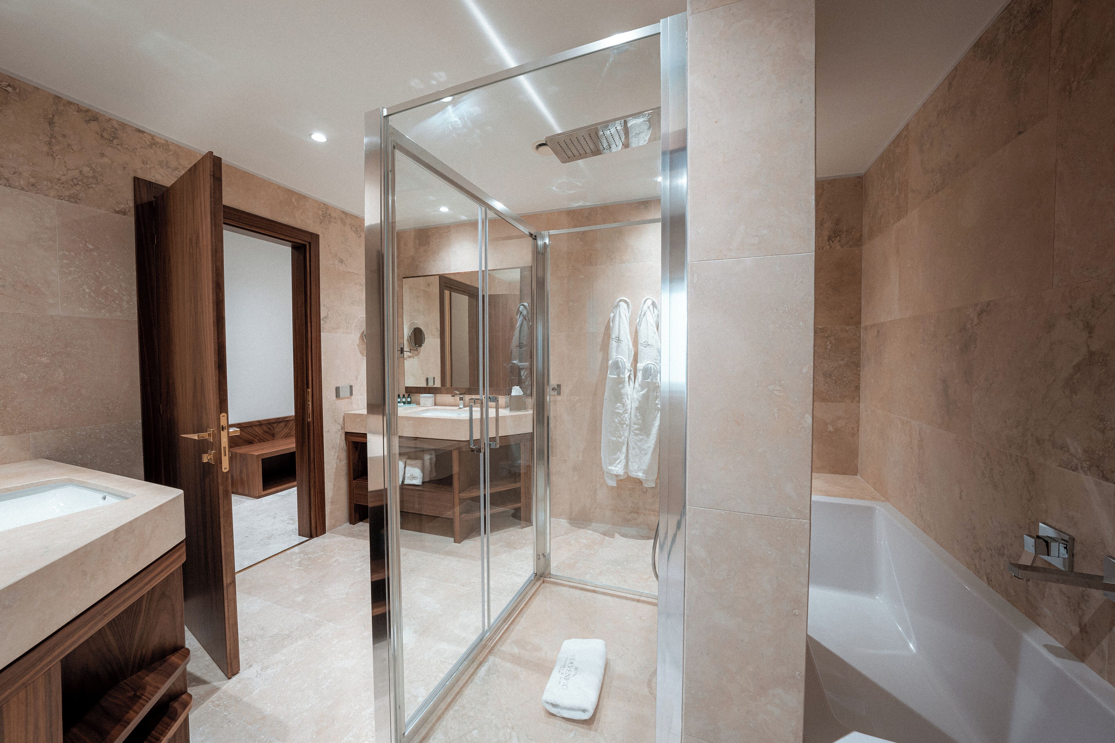 Une salle de bain moderne avec une douche à parois de verre, une baignoire et un meuble-lavabo avec un miroir.