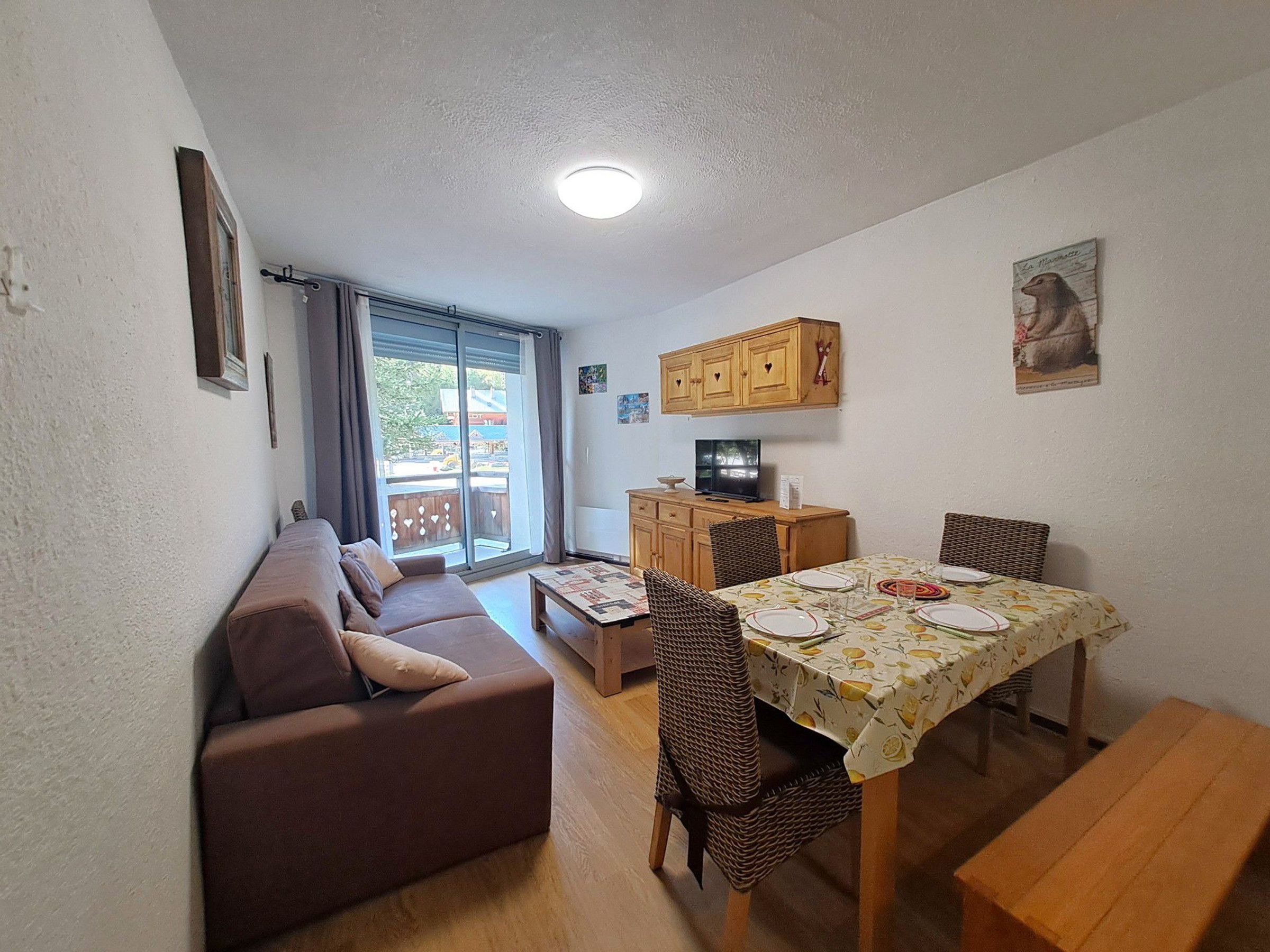 Ein gemütlicher, kleiner Wohnraum mit Sofa, Esstisch und Stühlen.