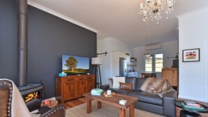 Uma sala de estar moderna com lareira, sofá e área de refeições.