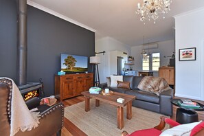 A modern living room with a fireplace, sofa, and a dining area. - The Glass Ceiling 360 degree Mount View Hideaway (Mount View)