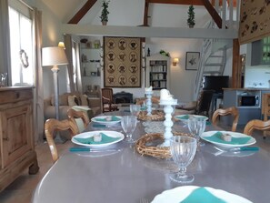 Enjoy meals in this beautifully appointed dining area with a long table, decorative centerpiece, and elegant glassware.