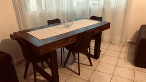 Taula de menjador amb un centre de taula de vidre, envoltada per quatre cadires.
