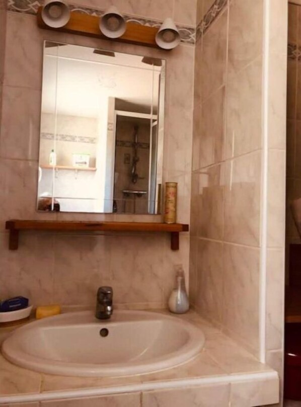 Une salle de bain équipée d’un lavabo, d’un miroir et d’un porte-serviettes.
