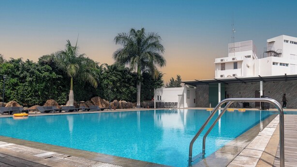Una piscina con sillas de descanso y un puesto de socorristas.