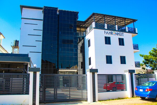 A modern building with a white facade, a black glass section, and a sign reading "FAHRENHEIT". - Fahrenheit Hotel (Abuja)
