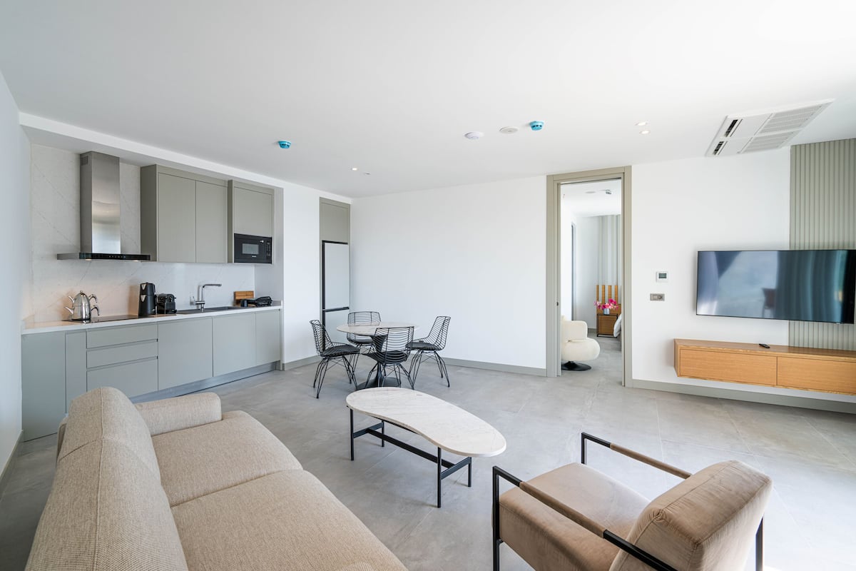 A modern living space with a kitchen, dining area, and seating area.