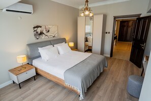 Un dormitorio con cama, mesitas de noche, armario y espejo.
