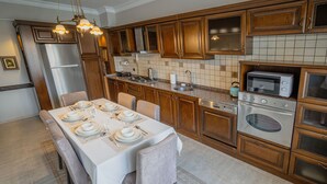 Eine Küche mit Holzschränken, einem Edelstahlkühlschrank, einer Mikrowelle und einem Herd.