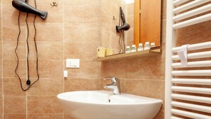A bathroom with a white sink, a mirror, and a towel rack. - BnButler - Pellegrino Rossi 42 (Milan)