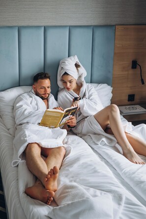 A couple in a hotel room, reading a book together. - Mielno Hotel Boutique (Mielno)