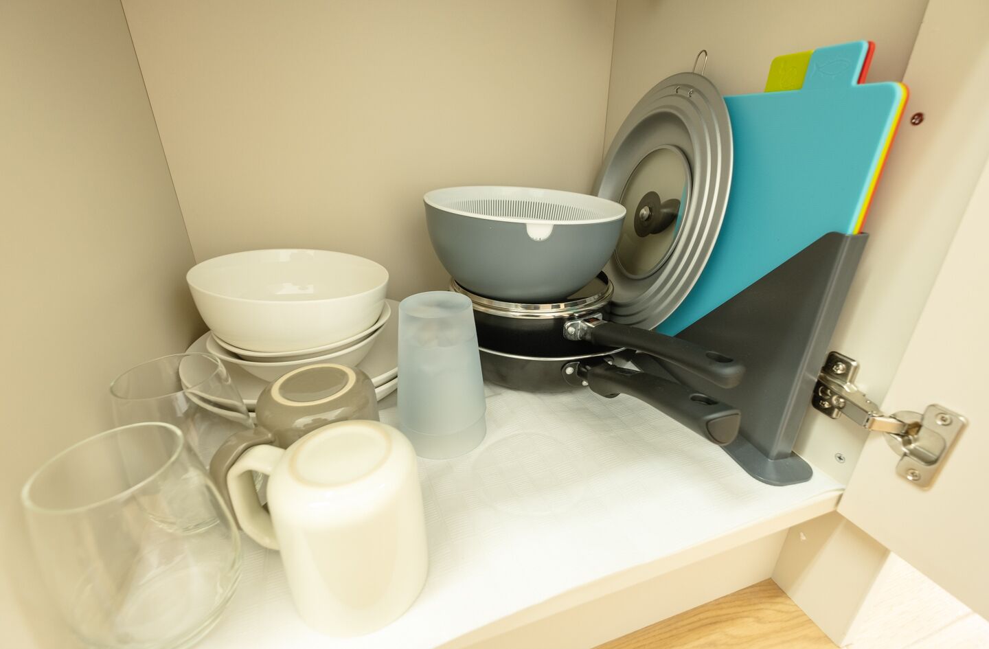 A kitchen counter with various dishes, a kettle, and a blue storage rack.