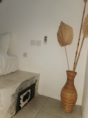 A room with a bed, a wall-mounted power outlet, a small electronic device, and a vase with dried plants. - Banana VILLA w/ private POOL garden and parking near Canggu (Badung)
