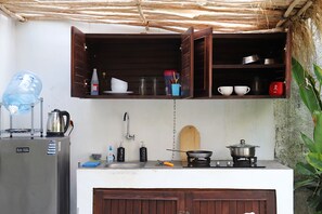 A compact kitchen with a refrigerator, a sink, a stove, and open wooden cabinets above. - Banana VILLA w/ private POOL garden and parking near Canggu (Badung)