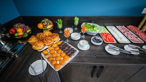 A buffet table with various food items and utensils.