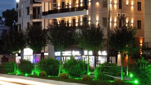 A multi-story hotel with illuminated signage and a well-lit facade.