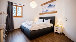 Una camera da letto moderna con un letto grande, comodini, un armadio e una finestra con tende.