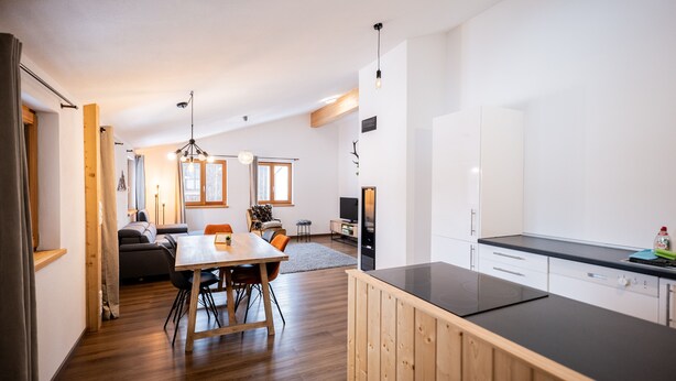 Una cucina moderna con mobili in legno e un piano di lavoro nero.