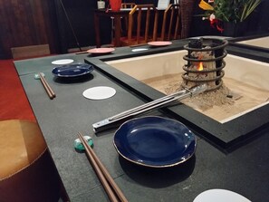 A dining table with chopsticks, plates, and a small fire feature. - Retro Romantic Room! Private rooftop room with a view of Tokyo Bay beyond the Uraga Dock. (Yokosuka city)
